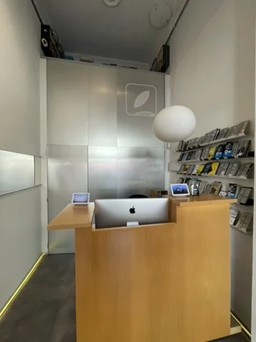 Jinank iRepair interior — what the customer sees walking in: counter with iMac, logo and spherical lamp